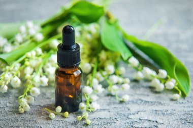 Vadideki zambak, küçük bir şişede gerekli yağ. Seçici odaklanma. Doğa.