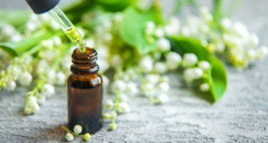 Vadideki zambak, küçük bir şişede gerekli yağ. Seçici odaklanma. Doğa.