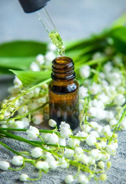 Vadideki zambak, küçük bir şişede gerekli yağ. Seçici odaklanma. Doğa.