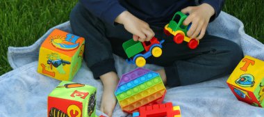 Silikon anti-stres oyuncağı. Çocuk çimenlerde oynuyor. Yeni eğilim Seçici odak. Doğa
