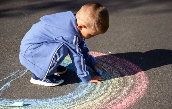 Niño Dibuja Con Tiza Los Colores Del Arco Iris Sobre — Foto de Stock