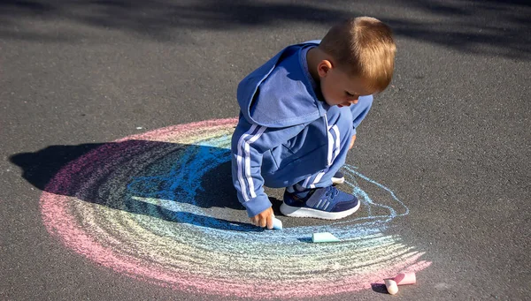 Das Kind Zeichnet Mit Kreide Die Farben Des Regenbogens Auf — Stockfoto