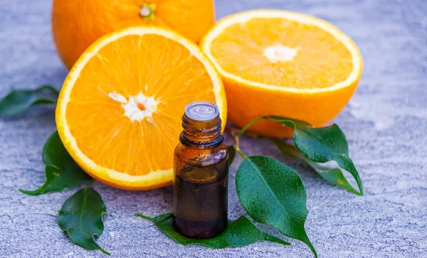 Şişe içinde portakal yağı, arka planda taze meyve parçaları. Doğal tatlar. Seçici odak