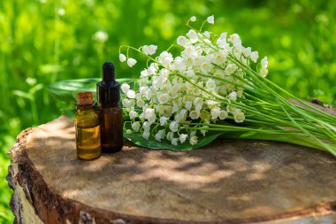 Vadideki zambak, küçük bir şişede gerekli yağ. Seçici odaklanma. Doğa.