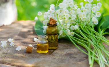 Vadideki zambak, küçük bir şişede gerekli yağ. Seçici odaklanma. Doğa.