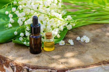 Vadideki zambak, küçük bir şişede gerekli yağ. Seçici odaklanma. Doğa.