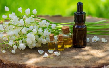 Vadideki zambak, küçük bir şişede gerekli yağ. Seçici odaklanma. Doğa.