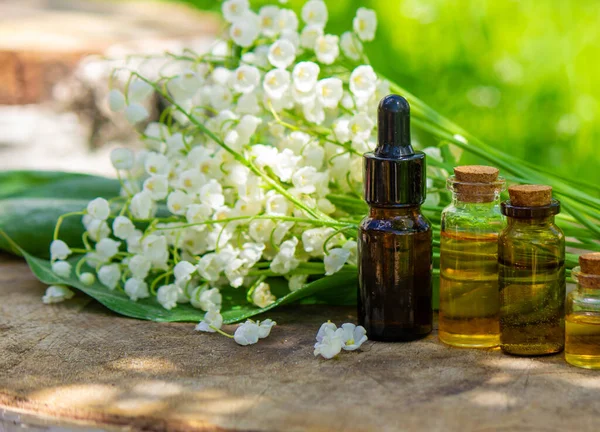 Vadideki zambak, küçük bir şişede gerekli yağ. Seçici odaklanma. Doğa.