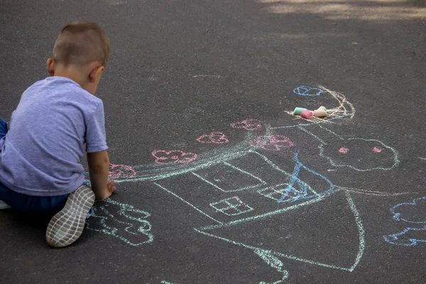 children drawing on asphalt family house. Selective focus