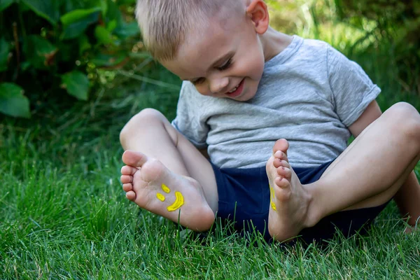 Niño Estaba Acostado Hierba Verde Sonríe Con Pinturas Las Piernas —  Fotos de Stock