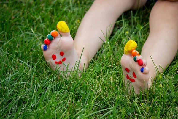 Çocuk Yeşil Çimlerin Üzerinde Yatıyordu Bacaklarında Kollarında Boyalarla Gülümse Çocuk — Stok fotoğraf