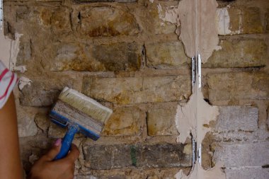 Kadın bir fırçayla duvarı boyuyor. İnşaat. Seçici odak