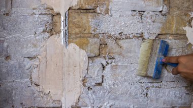 Kadın bir fırçayla duvarı boyuyor. İnşaat. Seçici odak