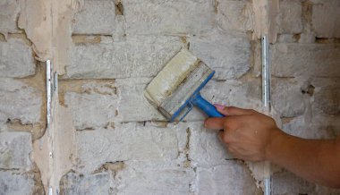 Kadın bir fırçayla duvarı boyuyor. İnşaat. Seçici odak