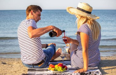 Deniz kenarında şarap içen romantik bir çift. Seçici odak