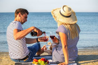 Deniz kenarında şarap içen romantik bir çift. Seçici odak