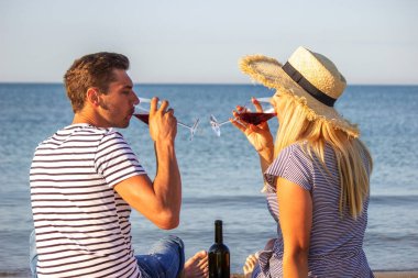 Deniz kenarında şarap içen romantik bir çift. Seçici odak