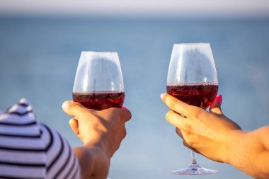 Deniz kenarında şarap içen romantik bir çift. Seçici odak