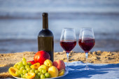 Pikniková přikrývka, víno, ovoce, krásná mořská pláž. Selektivní zaměření