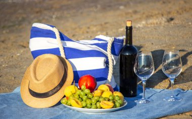 Piknik battaniyesi, şarap, meyve, güzel deniz plajı. Seçici odak