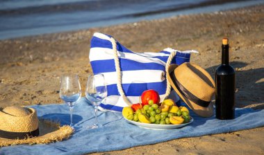 Piknik battaniyesi, şarap, meyve, güzel deniz plajı. Seçici odak