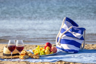Piknik battaniyesi, şarap, meyve, güzel deniz plajı Seçici odak