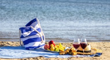 Piknik battaniyesi, şarap, meyve, güzel deniz plajı Seçici odak