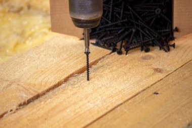 Adam evde tamirat yapıyor, tornavida, vida, testere. Ahşap zemin. Seçici odak