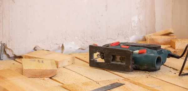 一个人用电锯切木板.修理房子里的地板。有选择的重点. — 图库照片