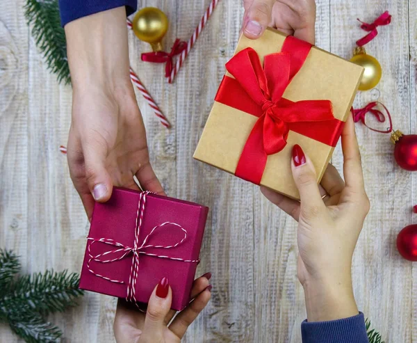 New Year\'s gifts in hands on a wooden background. Christmas selective focus