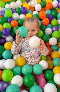 Mutlu Kız Renkli Top havuzunda Oynuyor ve Yalan Söylüyor.