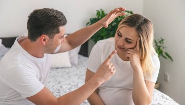 Adam hamile bir kadını azarlıyor. Seçici odaklanma. Ev.