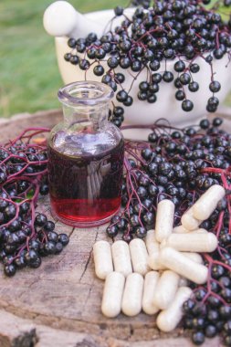 Doğal soğuk algınlığı ve grip ilacı için böğürtlen, şurup ve bitkisel destek kapsülleri.