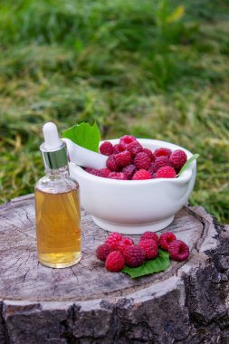 Havanda taze ahududu ve bir şişe doğal bitkisel özü ya da açık havada gerekli yağ.