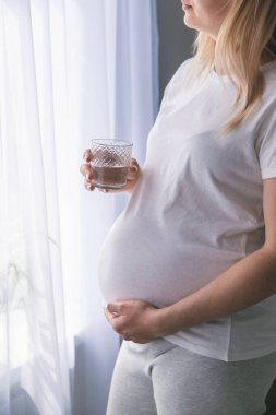 Hamile bir kadın su içer. Seçici odaklanma. Şirin..