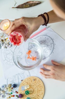 Bir masada astrolojik çizelgeler, kristaller ve rünlerle seroman balmumu kehanet ritüeli.