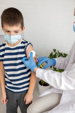 Doktor hastanın koluna, aşısına ve hastalığın önlenmesine aşı yapıyor..