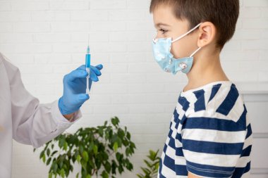 Maskeli Hild, doktorun ofisinde aşı yaptırıyor, aşıyı yaptırıyor ve önlüyor..