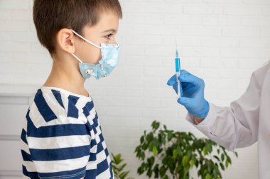 Maskeli Hild, doktorun ofisinde aşı yaptırıyor, aşıyı yaptırıyor ve önlüyor..