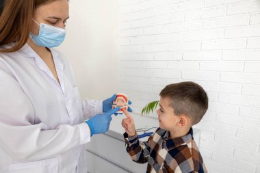 Diş hekimi, dişlerini nasıl fırçalayacağını gösteriyor..