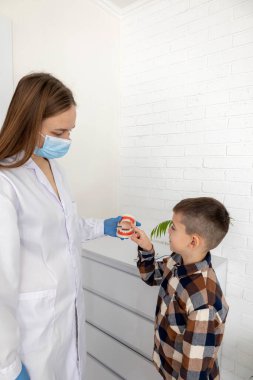 Diş hekimi, dişlerini nasıl fırçalayacağını gösteriyor..