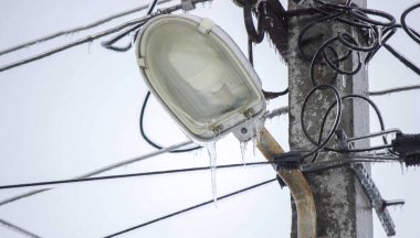 Dondurucu yağmurdan sonra buzla kaplı elektrik hatları ve buz saçakları. Kış.
