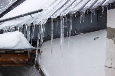 Kar yağarken çatıdan sarkan keskin buz saçakları. Kış havası