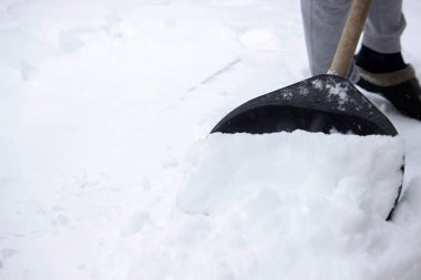 Siyah kürekle taze kar küremek, kışlık arazi bakımı