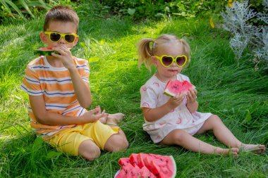Güneş gözlüklü kardeşlerim yazın çimenlerde karpuz yiyorlar.