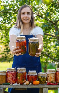 Doğanın arka planında salatalık konservesi yapan bir kadın. Seçici odak.
