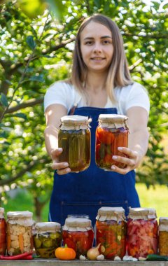 Doğanın arka planında salatalık konservesi yapan bir kadın. Seçici odak.