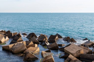 Yapay kayalar bir dalgakıran oluşturuyor. Akdeniz, güneşli bir kış günü