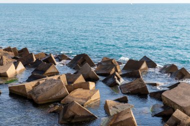 Yapay kayalar bir dalgakıran oluşturuyor. Akdeniz, güneşli bir kış günü