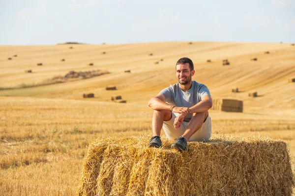 Handsome Smiling Young Guy Sitting Bale Wheat Field Just Mowed — Stock Photo, Image
